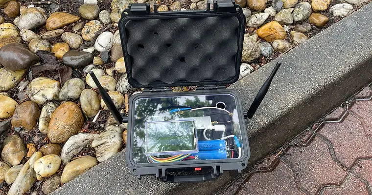 The replay device inside an open waterproof case, with two antennas and a touchscreen